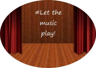 Empty theatre stage with "Let the music play" written on the back wall